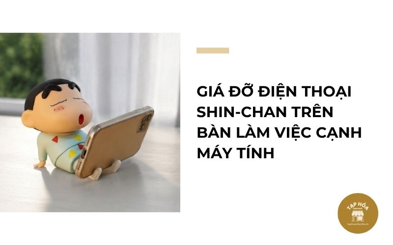 Giá đỡ điện thoại Shin-chan trên bàn làm việc cạnh máy tính
